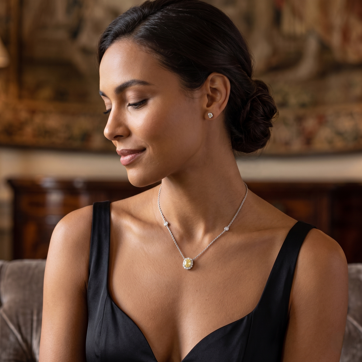 Woman wearing a necklace with a yellow gemstone in an elegant indoor setting