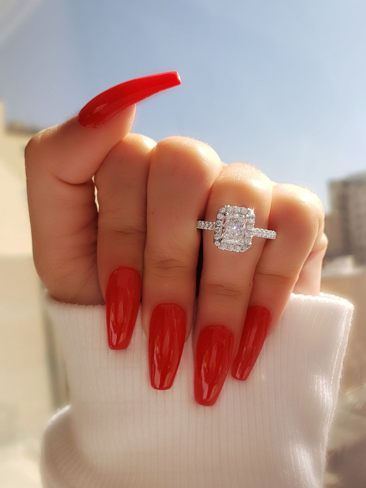Halo radiant cut engagement ring on hand