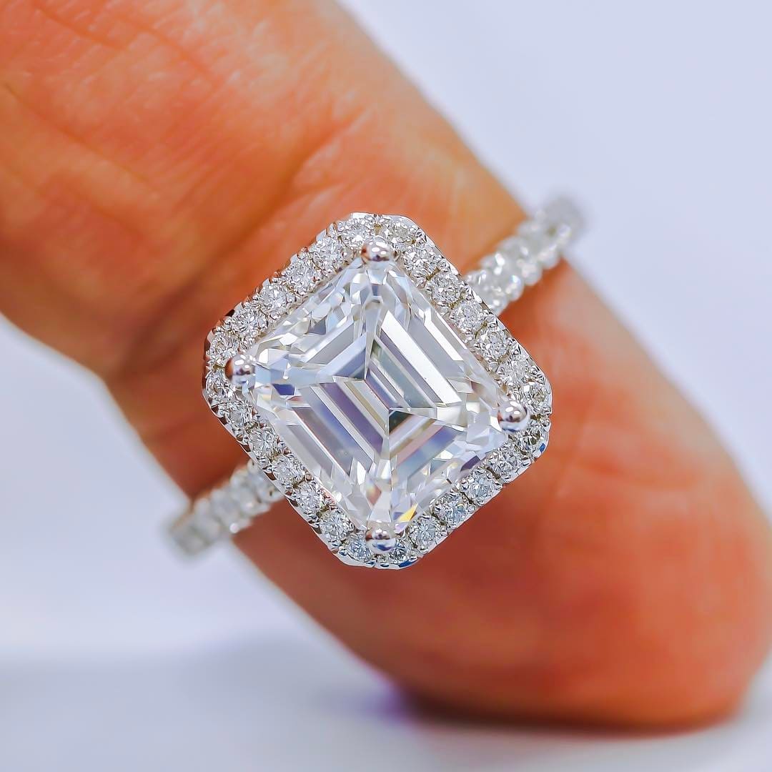 Halo emerald cut engagement ring on hand