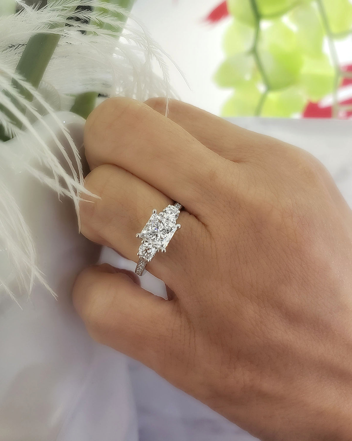 3 stone princess cut engagement ring with rounds on hand