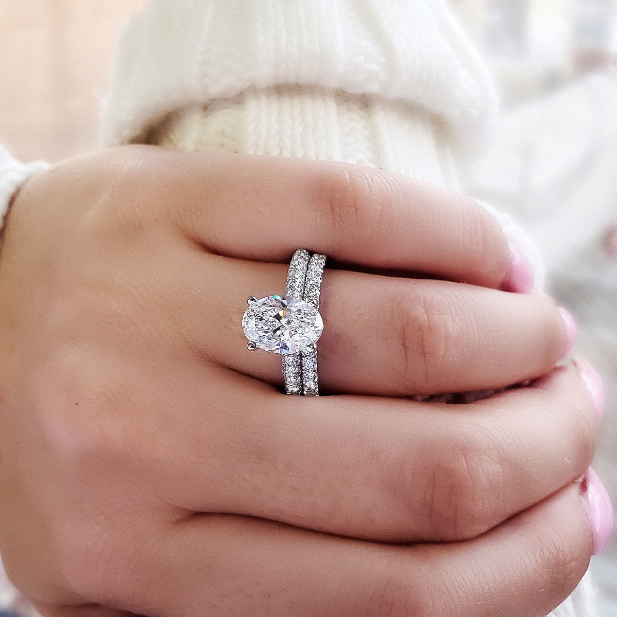 Hidden halo oval engagement ring on hand