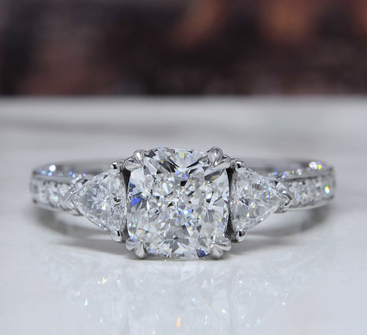 Diamond ring with triangular side stones on a white surface