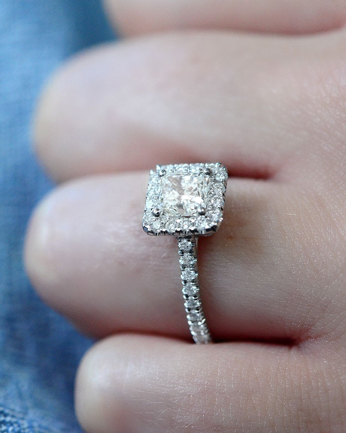 Princess cut halo engagement ring on hand