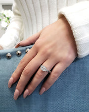 3 stone emerald cut diamond ring with half moons on hand