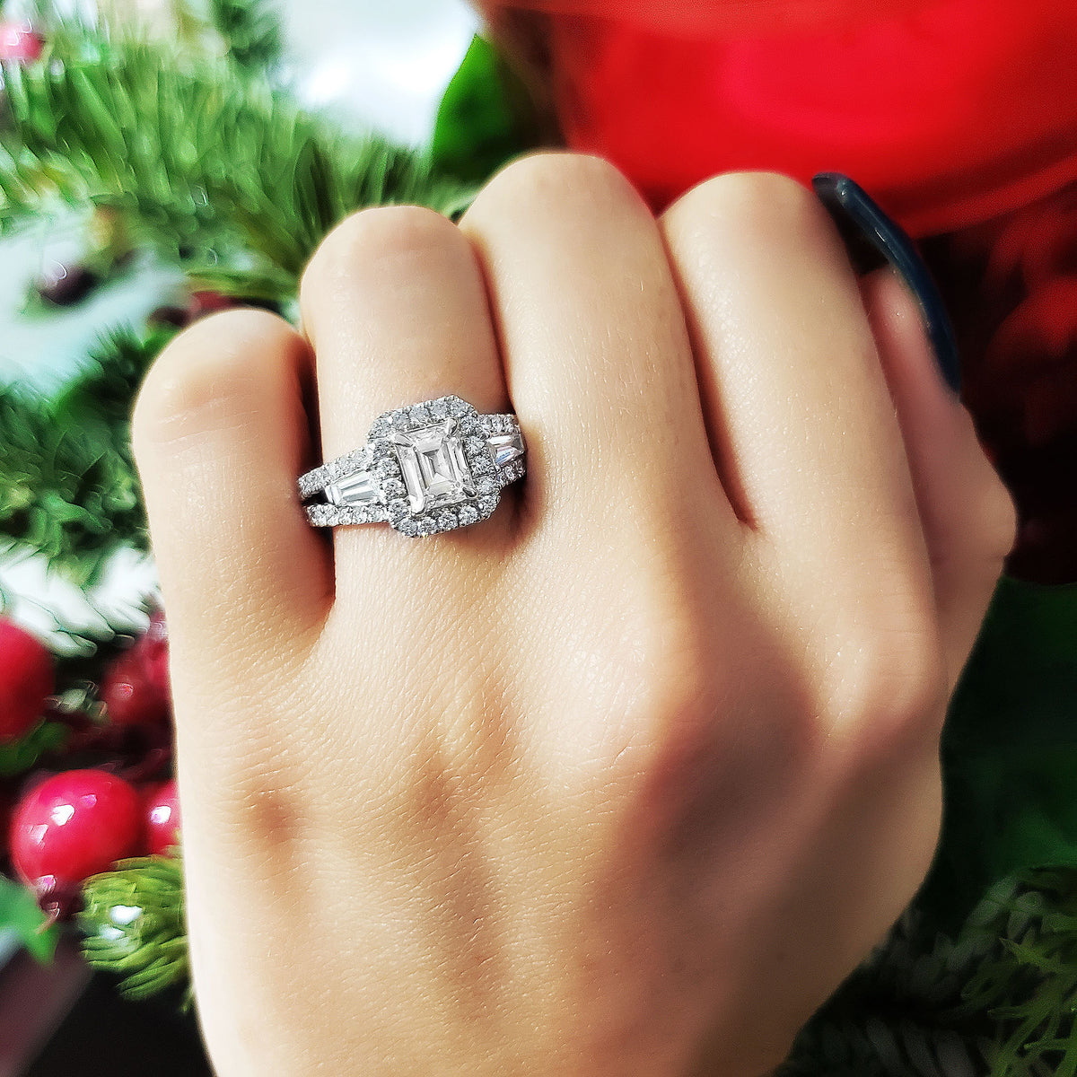 Emerald cut halo engagement ring on hand