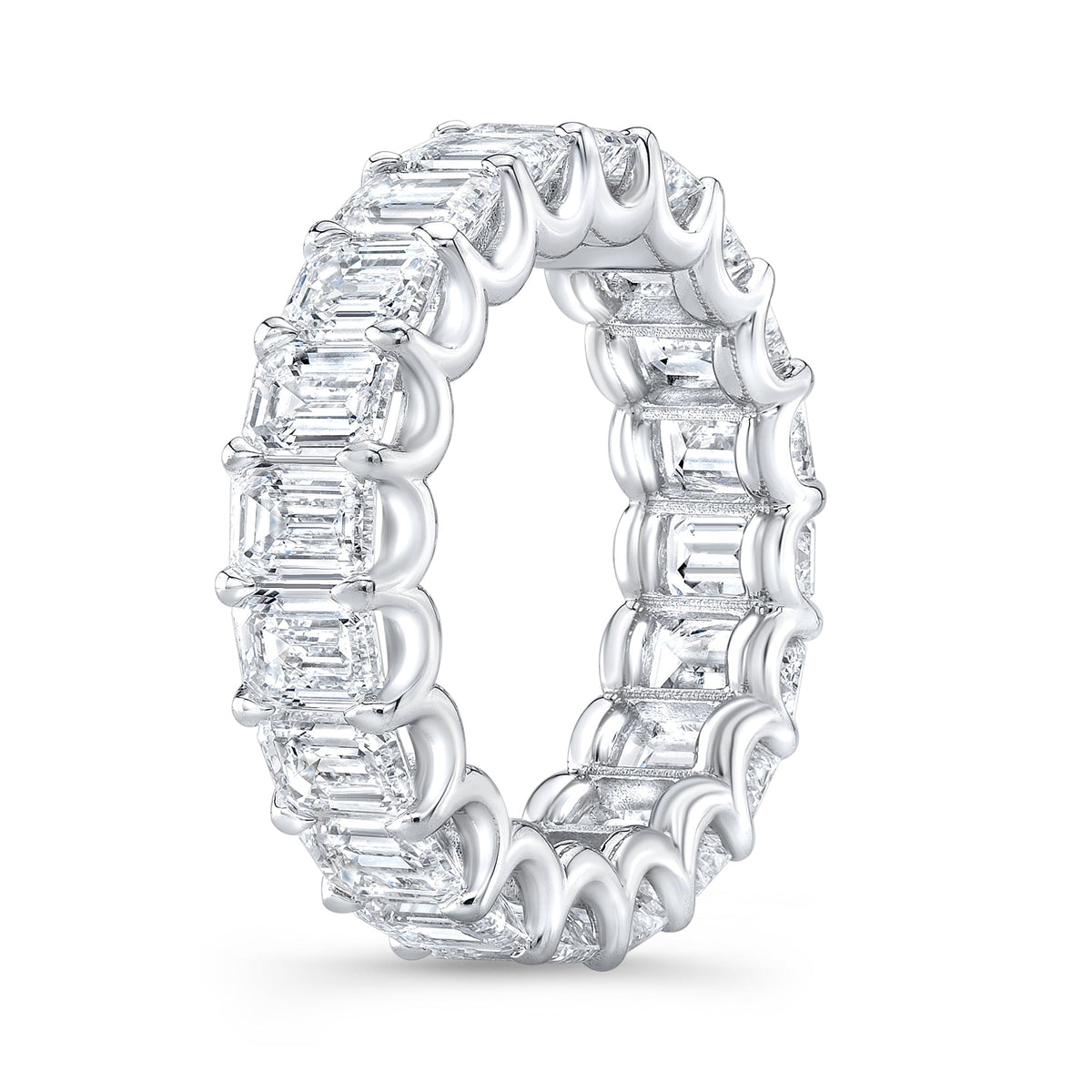 Diamond ring with emerald cut stones on a white background